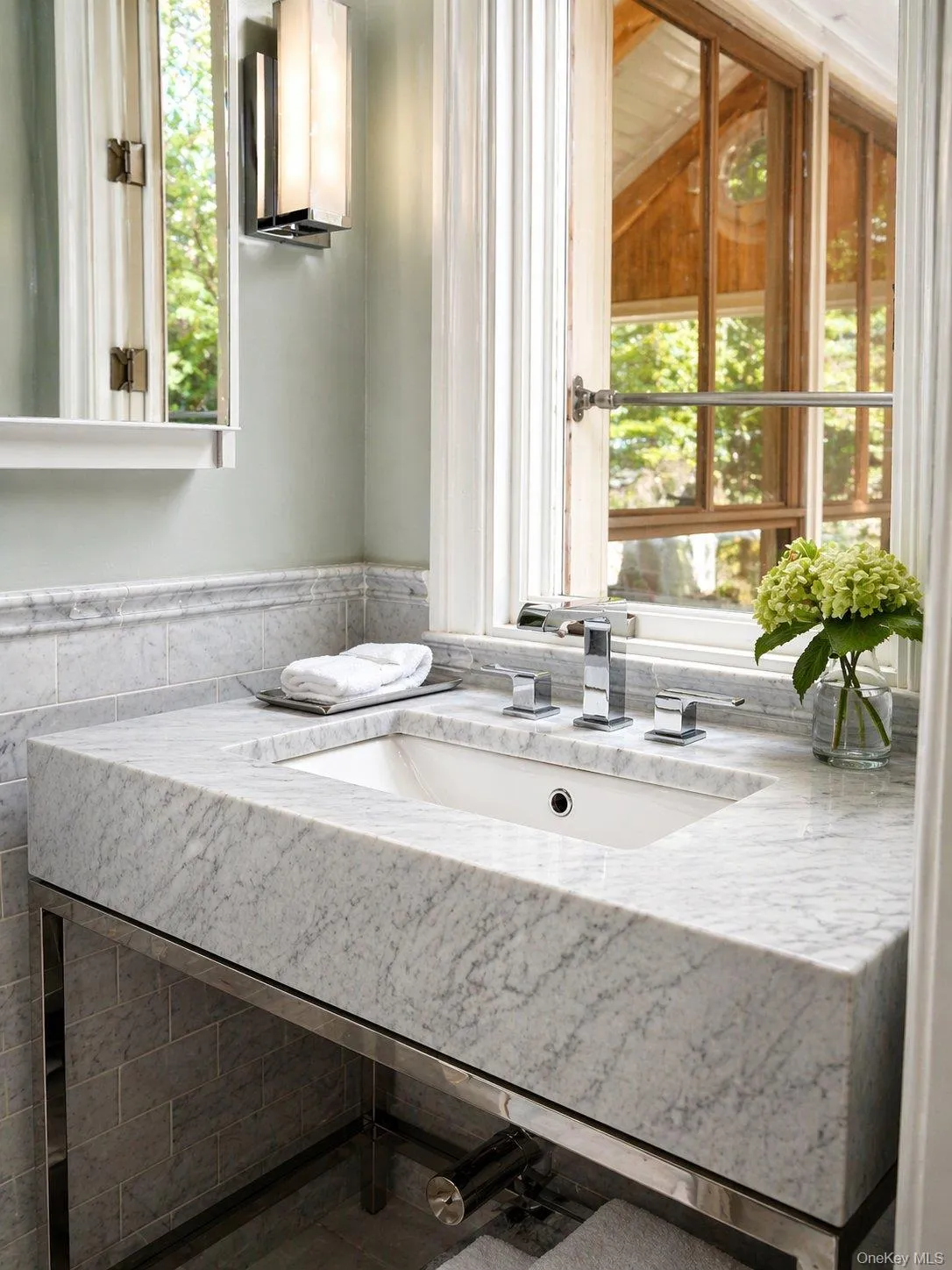 Bright bath with marble-topped vanity, generous counter space and natural light. Bright bath with marble-topped vanity, generous counter space and natural light.