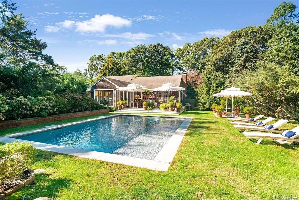 In-ground pool framed by lawn, mature landscaping and the rear of the home. In-ground pool framed by lawn, mature landscaping and the rear of the home.