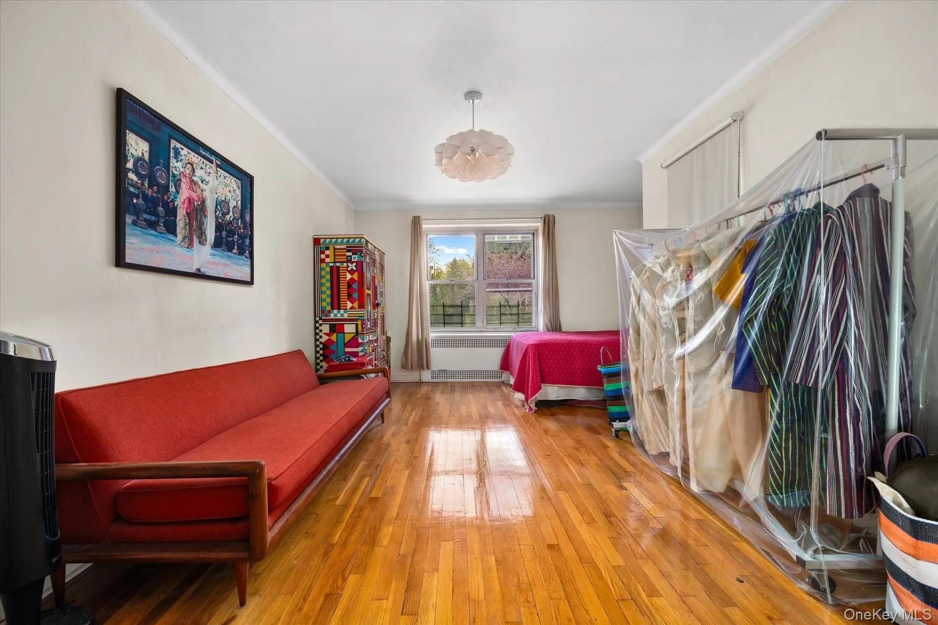 Expansive room featuring wood-finish flooring, white walls, and a window with natural light Expansive room featuring wood-finish flooring, white walls, and a window with natural light