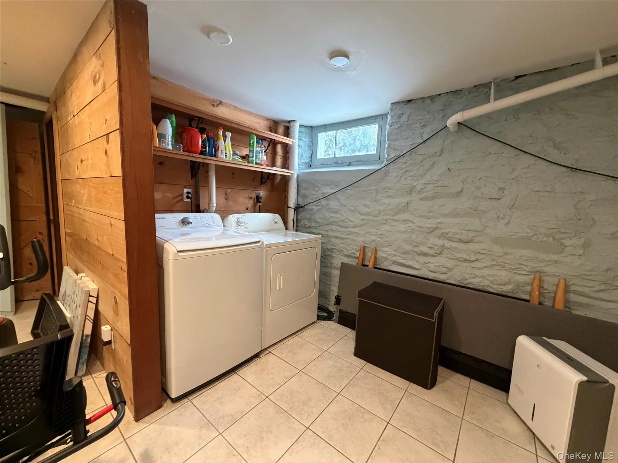 Laundry area featuring independent washer and dryer and light tile patterned floors Laundry area featuring independent washer and dryer and light tile patterned floors