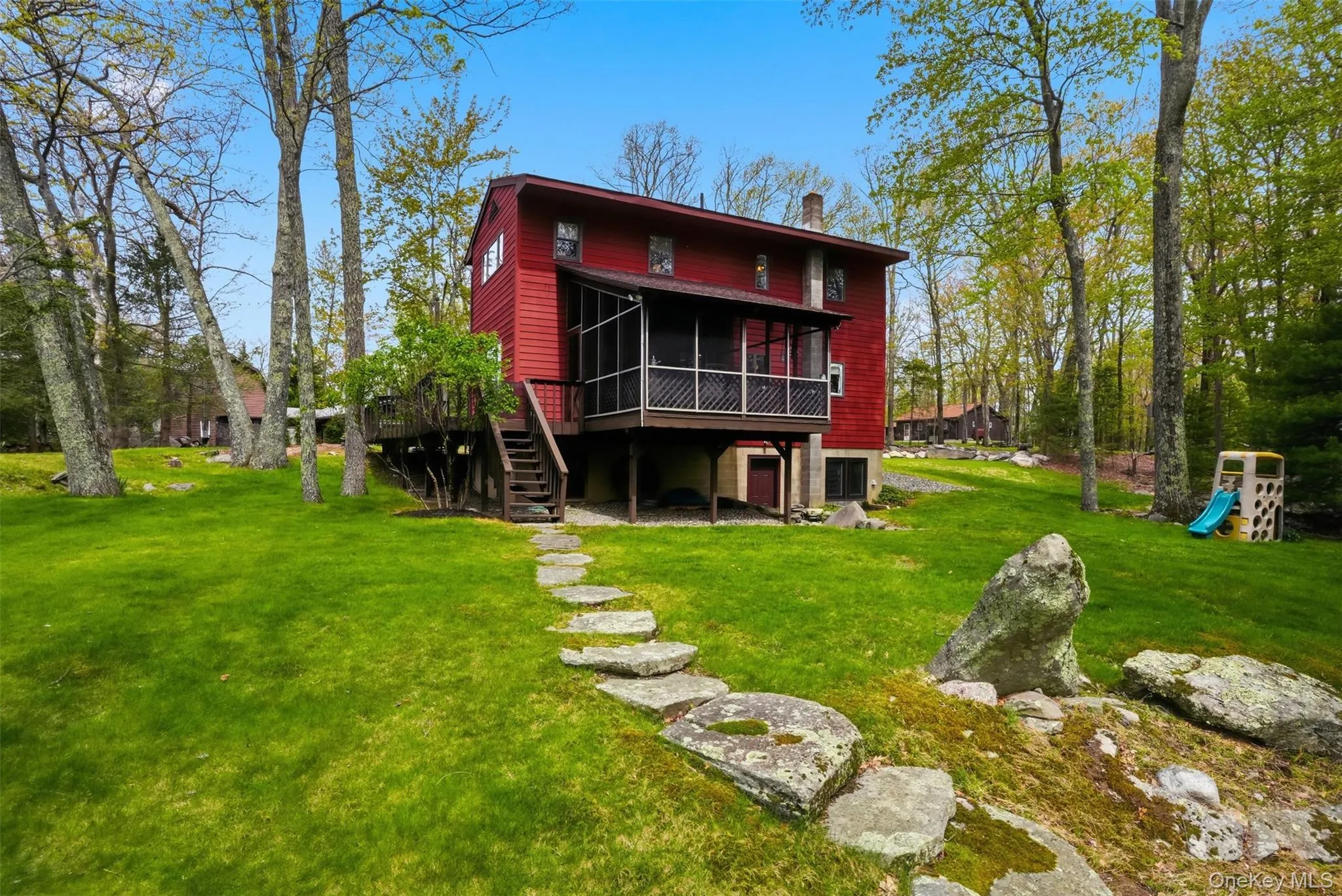 View of expansive green lawn and screened in porch. View of expansive green lawn and screened in porch.