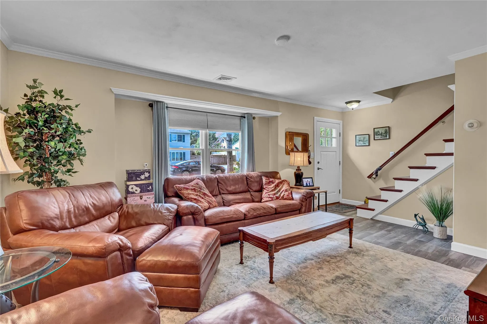 Spacious living room featuring beautiful wood look tiled flooring, sunny south facing windows Spacious living room featuring beautiful wood look tiled flooring, sunny south facing windows