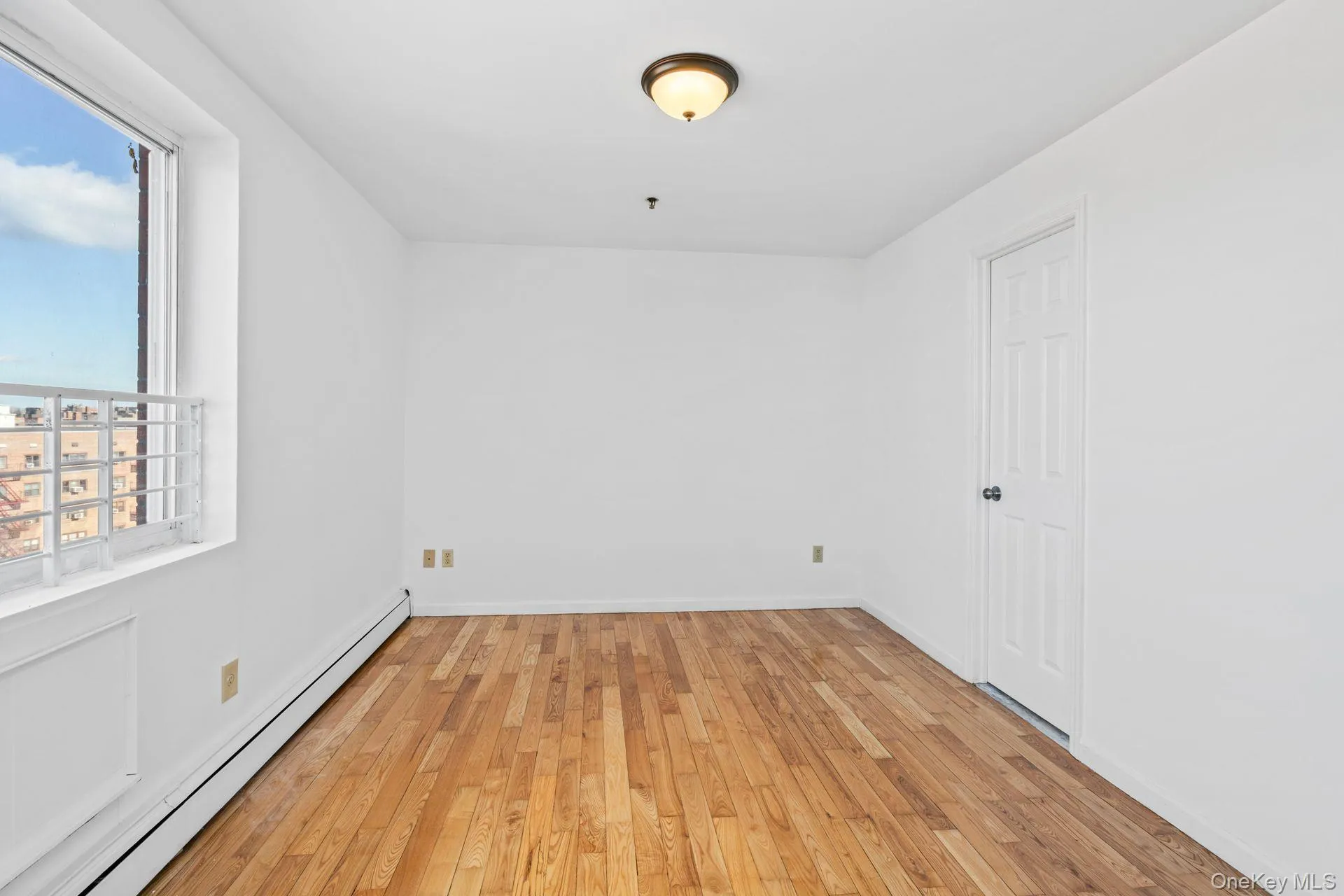 Empty room featuring a baseboard heating unit and light wood-type flooring Empty room featuring a baseboard heating unit and light wood-type flooring
