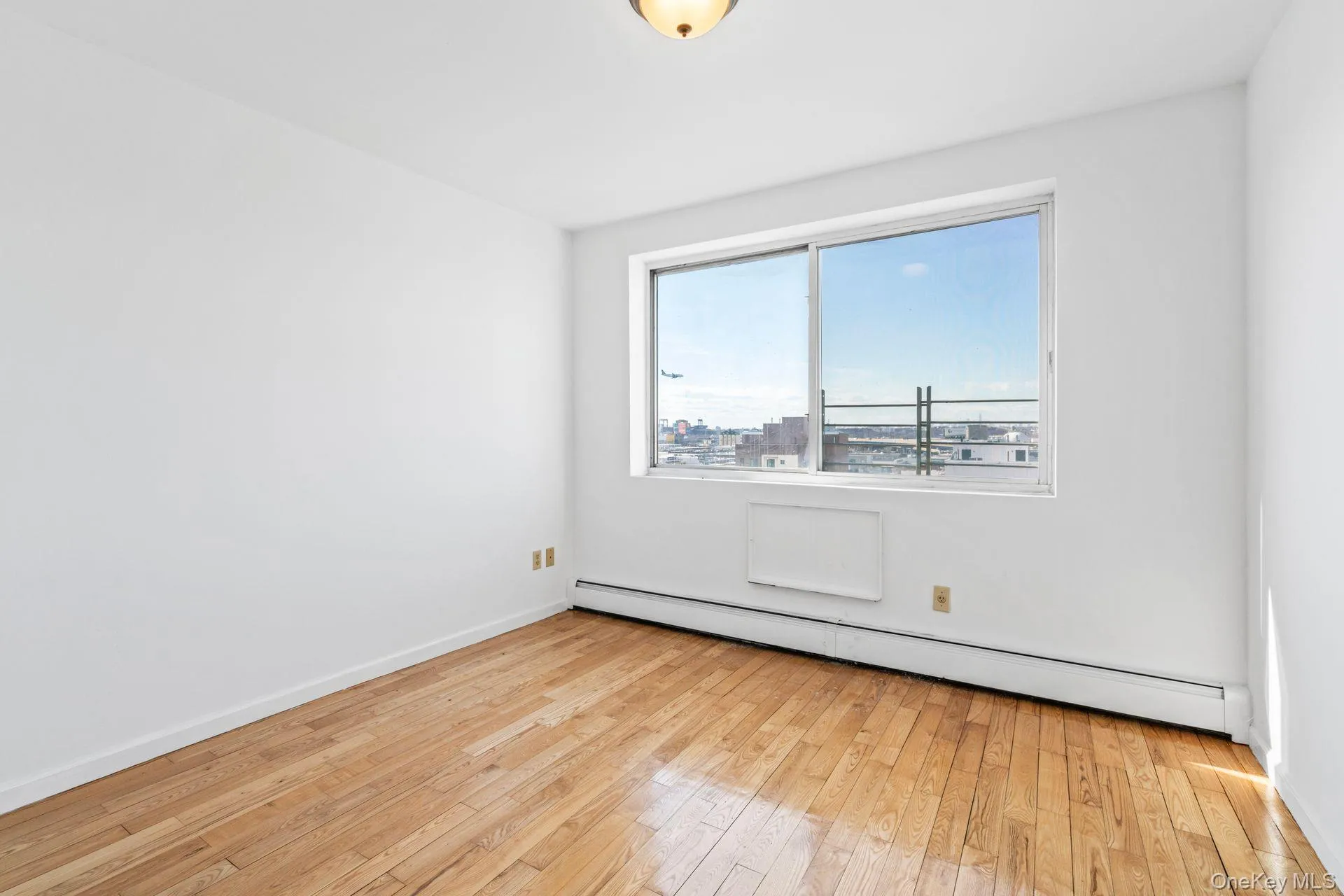 Empty room featuring light wood-type flooring and baseboard heating Empty room featuring light wood-type flooring and baseboard heating