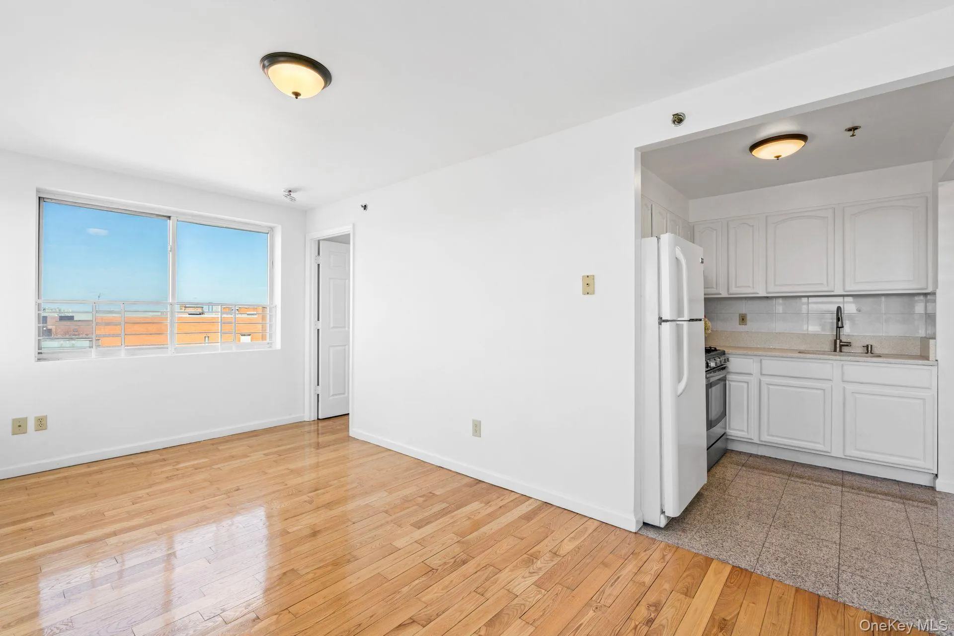 Kitchen with white cabinetry, sink, decorative backsplash, white refrigerator, and gas stove Kitchen with white cabinetry, sink, decorative backsplash, white refrigerator, and gas stove