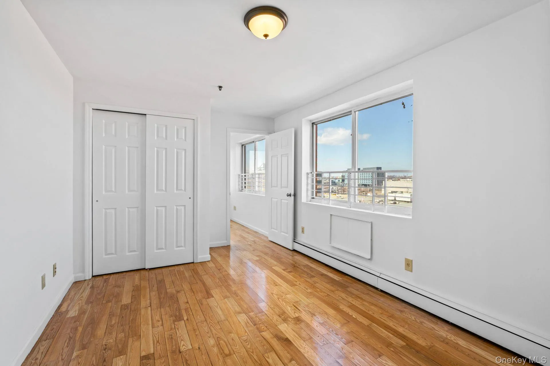 Unfurnished bedroom with a baseboard radiator, a closet, and light wood-type flooring Unfurnished bedroom with a baseboard radiator, a closet, and light wood-type flooring
