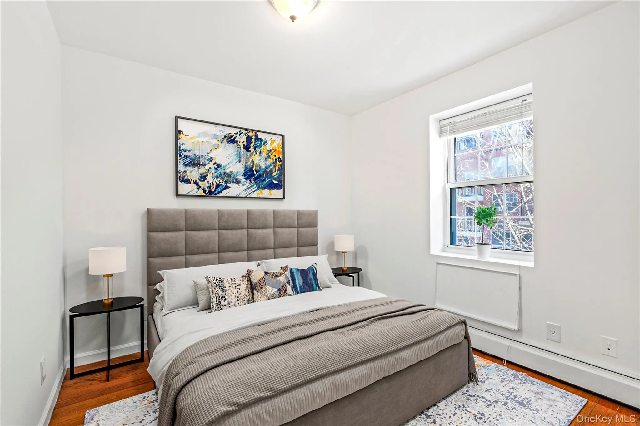 Virtual Staged Bedroom featuring baseboard heating, wood finished floors, and baseboards Virtual Staged Bedroom featuring baseboard heating, wood finished floors, and baseboards