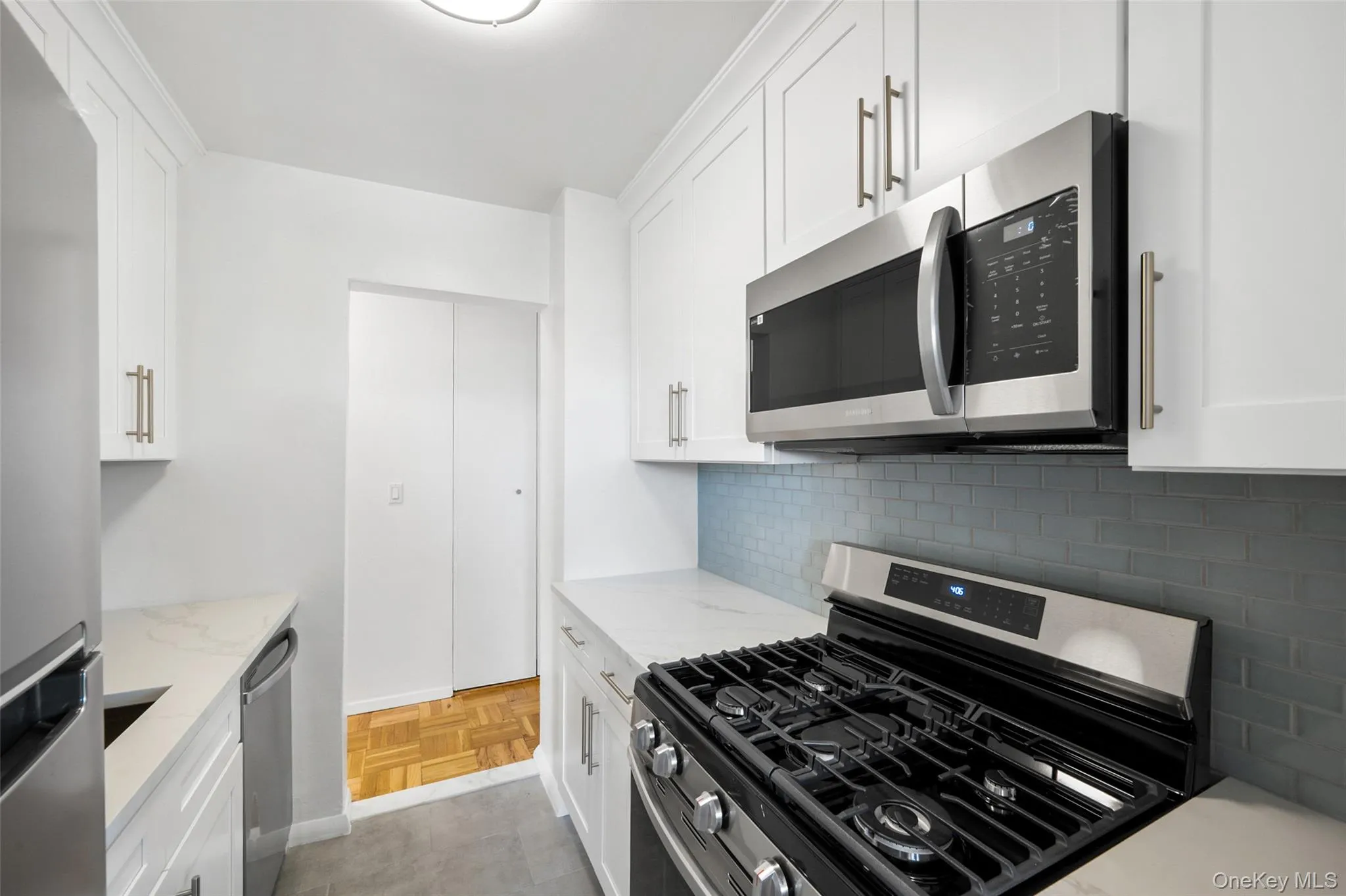 Brand New Fully renovated kitchen featuring white shaker-style cabinetry, stainless steel appliances, solid surface countertops, and a subway tile backsplash Brand New Fully renovated kitchen featuring white shaker-style cabinetry, stainless steel appliances, solid surface countertops, and a subway tile backsplash