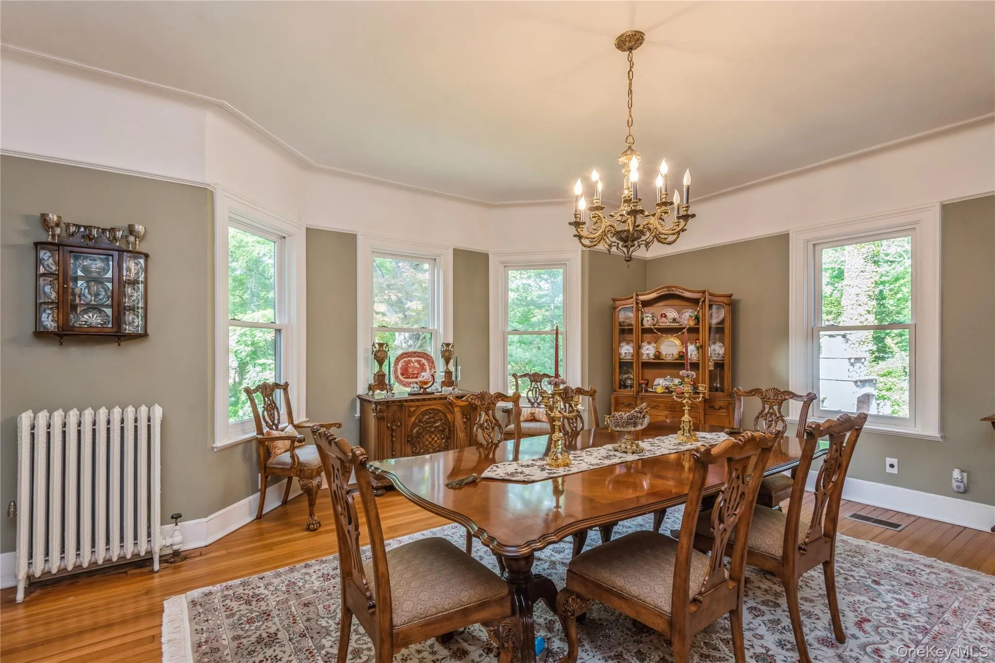 Formal dining room, complemented by a cast iron radiator and a classic chandelier Formal dining room, complemented by a cast iron radiator and a classic chandelier