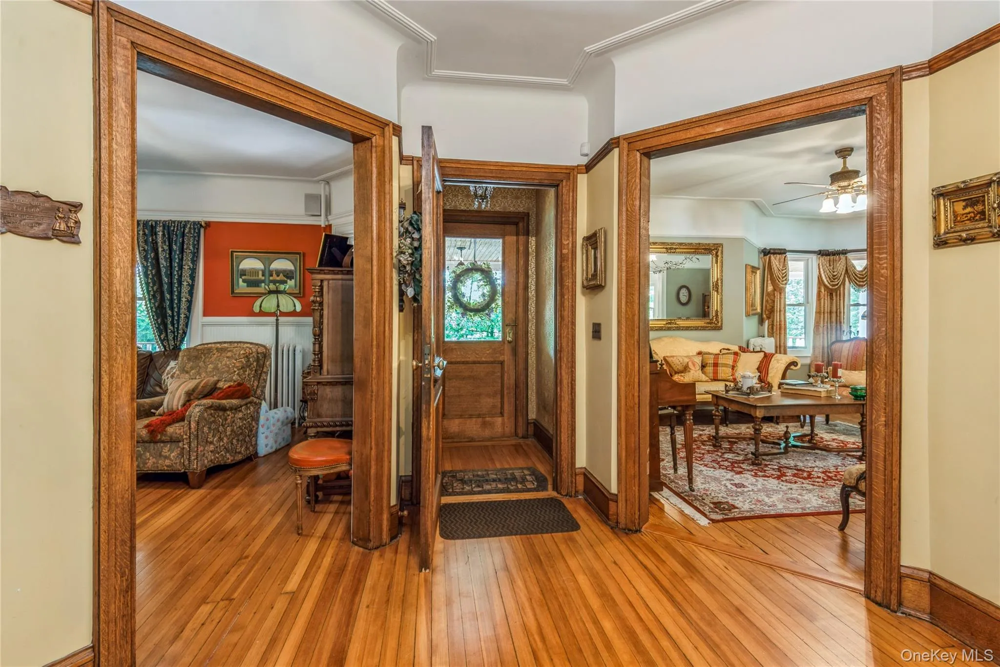 Hardwood flooring throughout the entry area, featuring ornate wood door frames and crown molding Hardwood flooring throughout the entry area, featuring ornate wood door frames and crown molding
