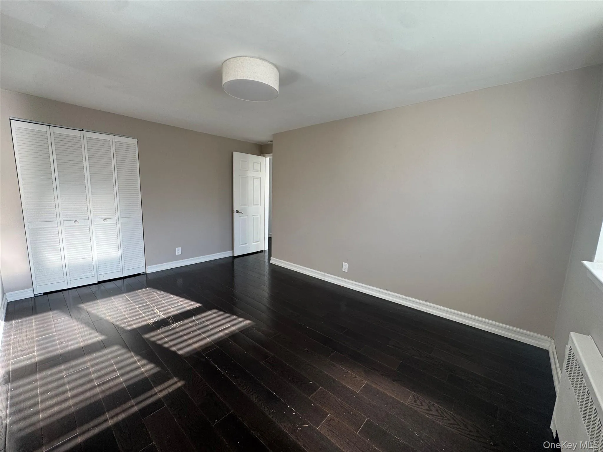 Unfurnished bedroom featuring visible vents, baseboards, a closet, and dark wood finished floors Unfurnished bedroom featuring visible vents, baseboards, a closet, and dark wood finished floors