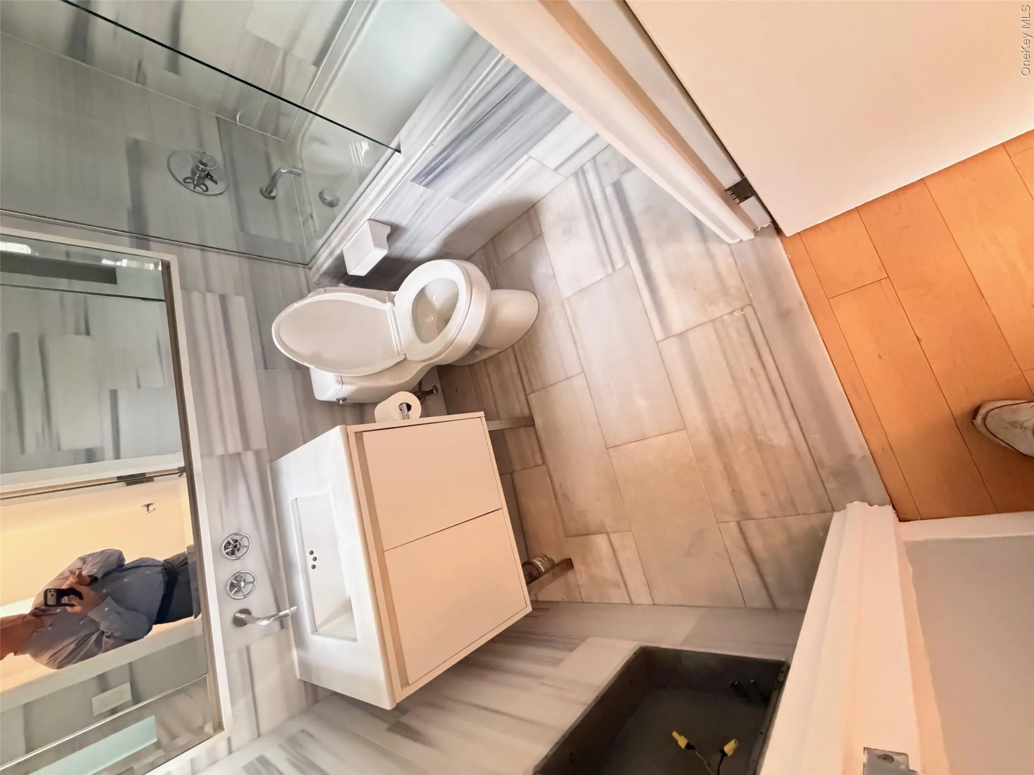 Bathroom featuring a white vanity with an integrated sink, chrome wall-mounted faucet, and a large mirror Bathroom featuring a white vanity with an integrated sink, chrome wall-mounted faucet, and a large mirror