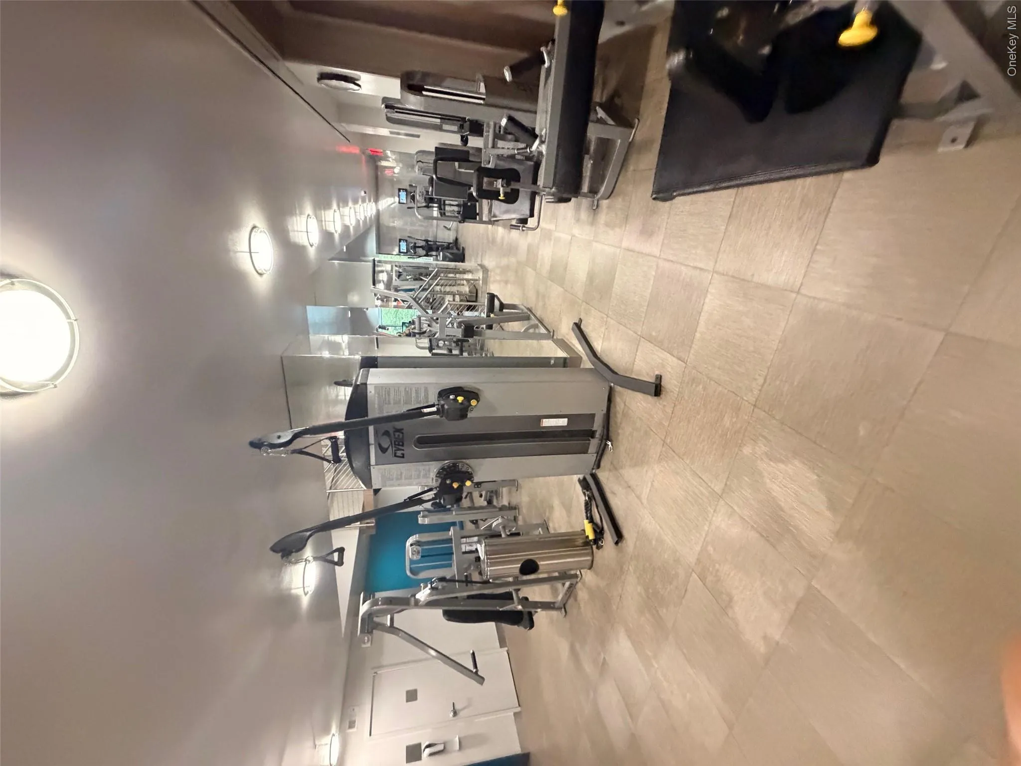 Fitness center featuring extensive exercise equipment, tile flooring, mirrored walls, and recessed lighting Fitness center featuring extensive exercise equipment, tile flooring, mirrored walls, and recessed lighting
