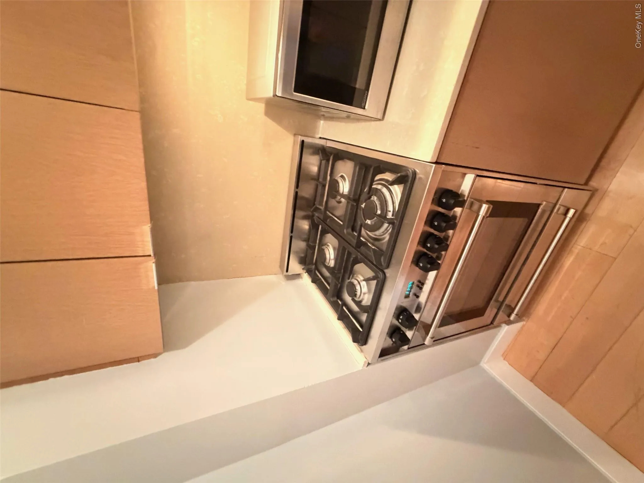 Stainless steel gas range with four burners, integrated oven, and brushed metal hardware Stainless steel gas range with four burners, integrated oven, and brushed metal hardware