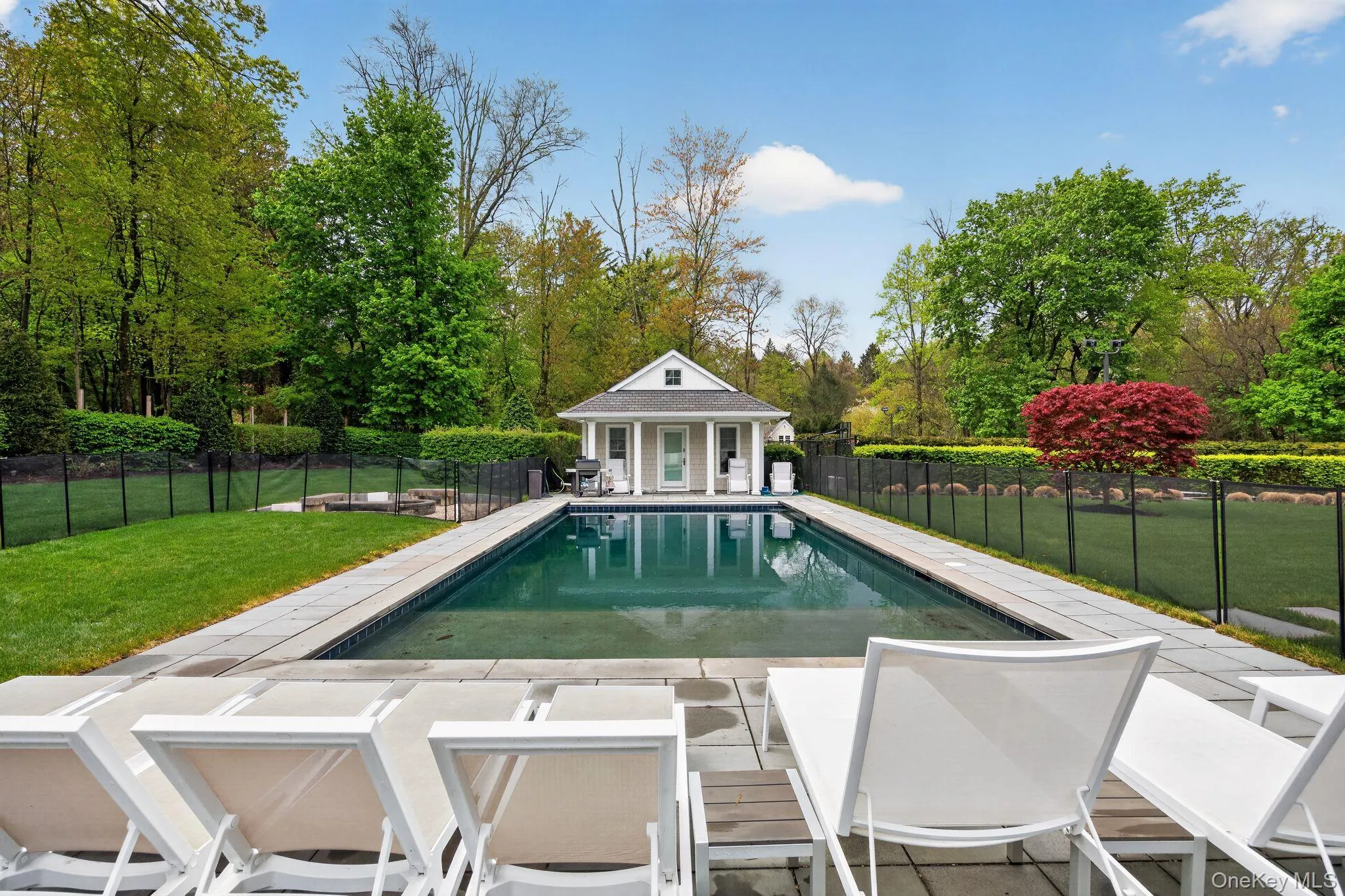 Rectangular in-ground swimming pool with a surrounding stone patio Rectangular in-ground swimming pool with a surrounding stone patio