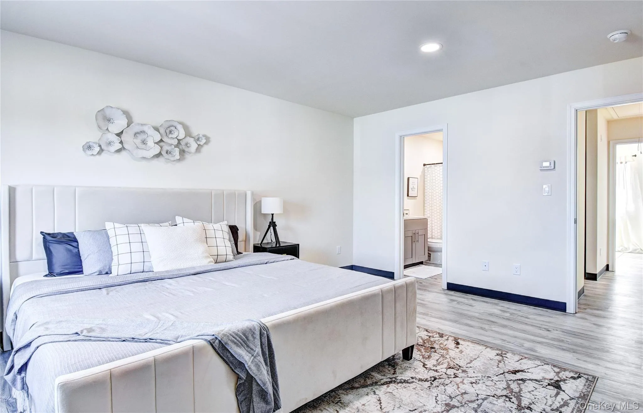 Bedroom with connected bathroom and light hardwood / wood-style flooring Bedroom with connected bathroom and light hardwood / wood-style flooring