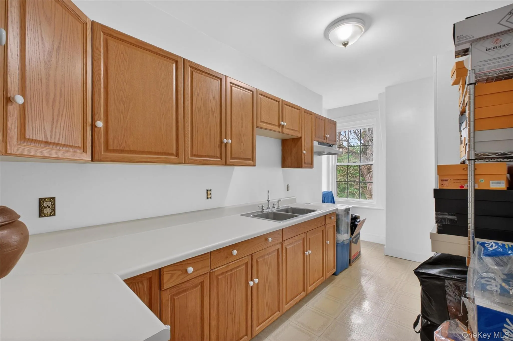 Kitchenette featuring light wood-finish cabinetry, white countertops, and a dual basin stainless steel sink - utilized for the legal accessory apartment/ADU Kitchenette featuring light wood-finish cabinetry, white countertops, and a dual basin stainless steel sink - utilized for the legal accessory apartment/ADU
