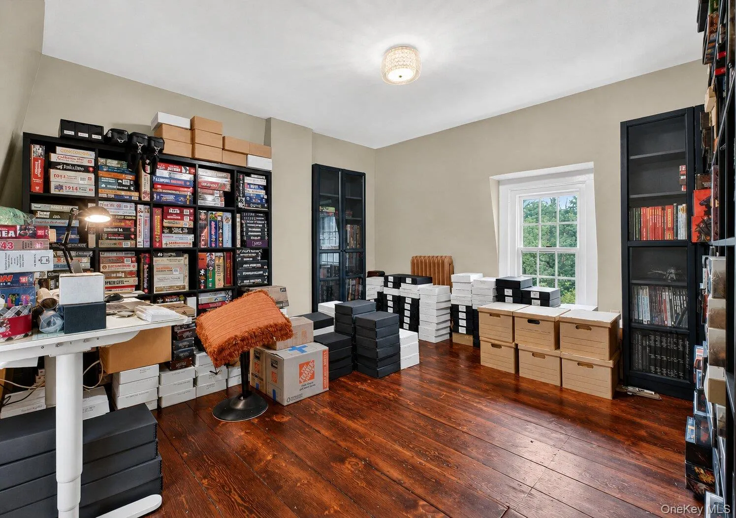 Room featuring rich wood-finish flooring, light tan wall color, a traditional window with white trim and large windows. Room featuring rich wood-finish flooring, light tan wall color, a traditional window with white trim and large windows.