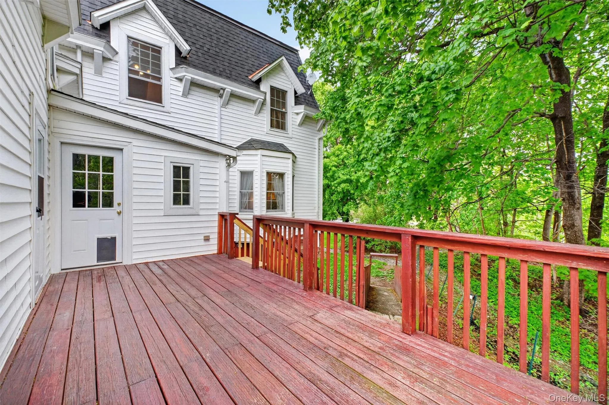 Spacious outdoor deck with wood flooring and matching railings, featuring a verdant tree canopy backdrop and integrated stairs. Spacious outdoor deck with wood flooring and matching railings, featuring a verdant tree canopy backdrop and integrated stairs.