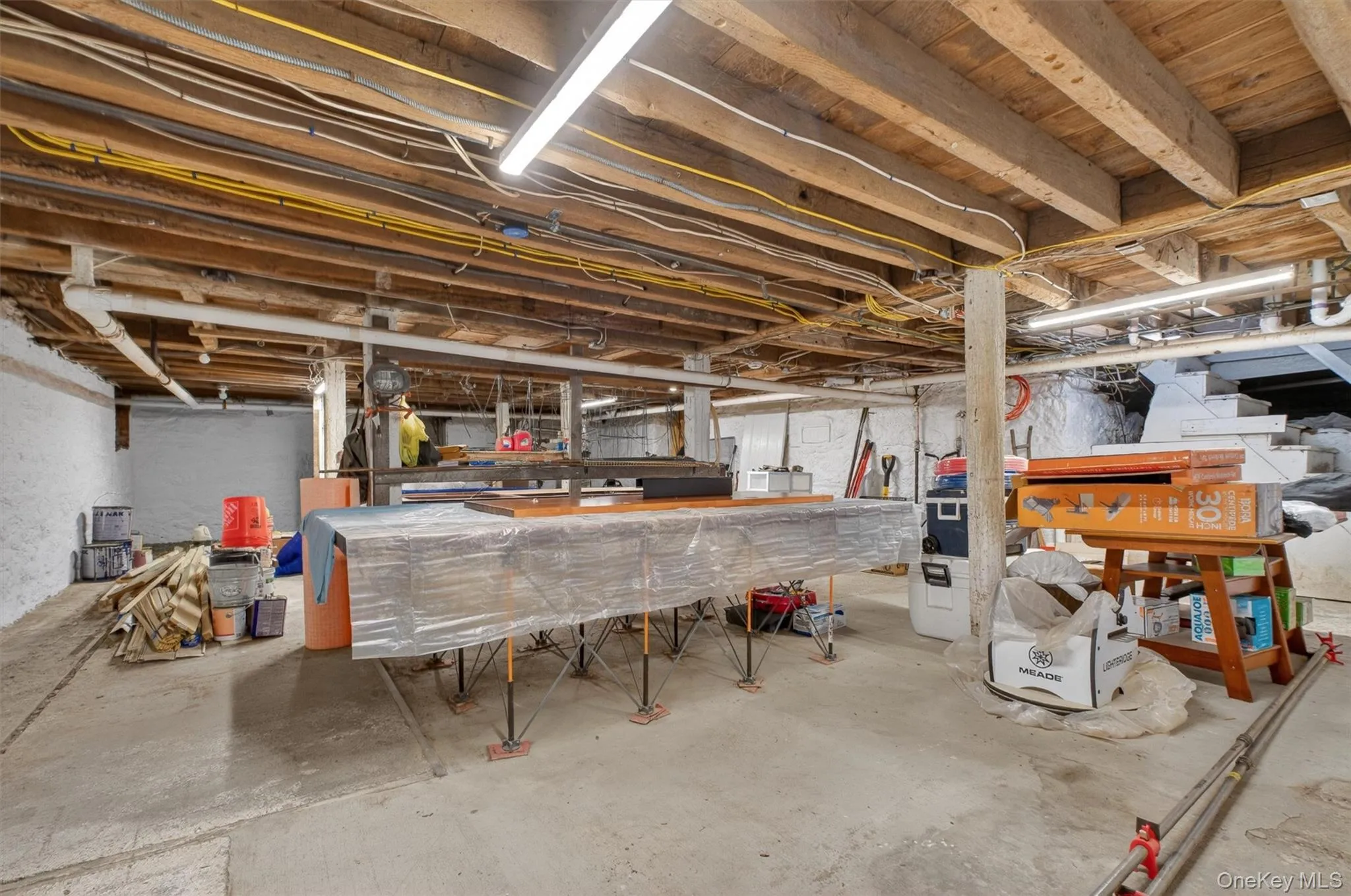 Spacious basement featuring exposed wood ceiling joists and concrete flooring with access to outdoors. Spacious basement featuring exposed wood ceiling joists and concrete flooring with access to outdoors.