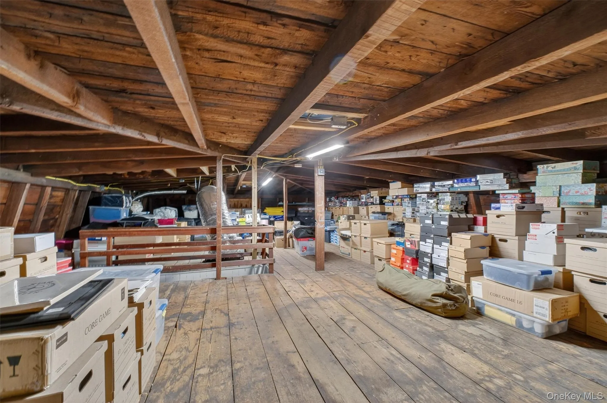 Expansive attic space featuring exposed wood beam ceiling and wood-finish flooring. Expansive attic space featuring exposed wood beam ceiling and wood-finish flooring.