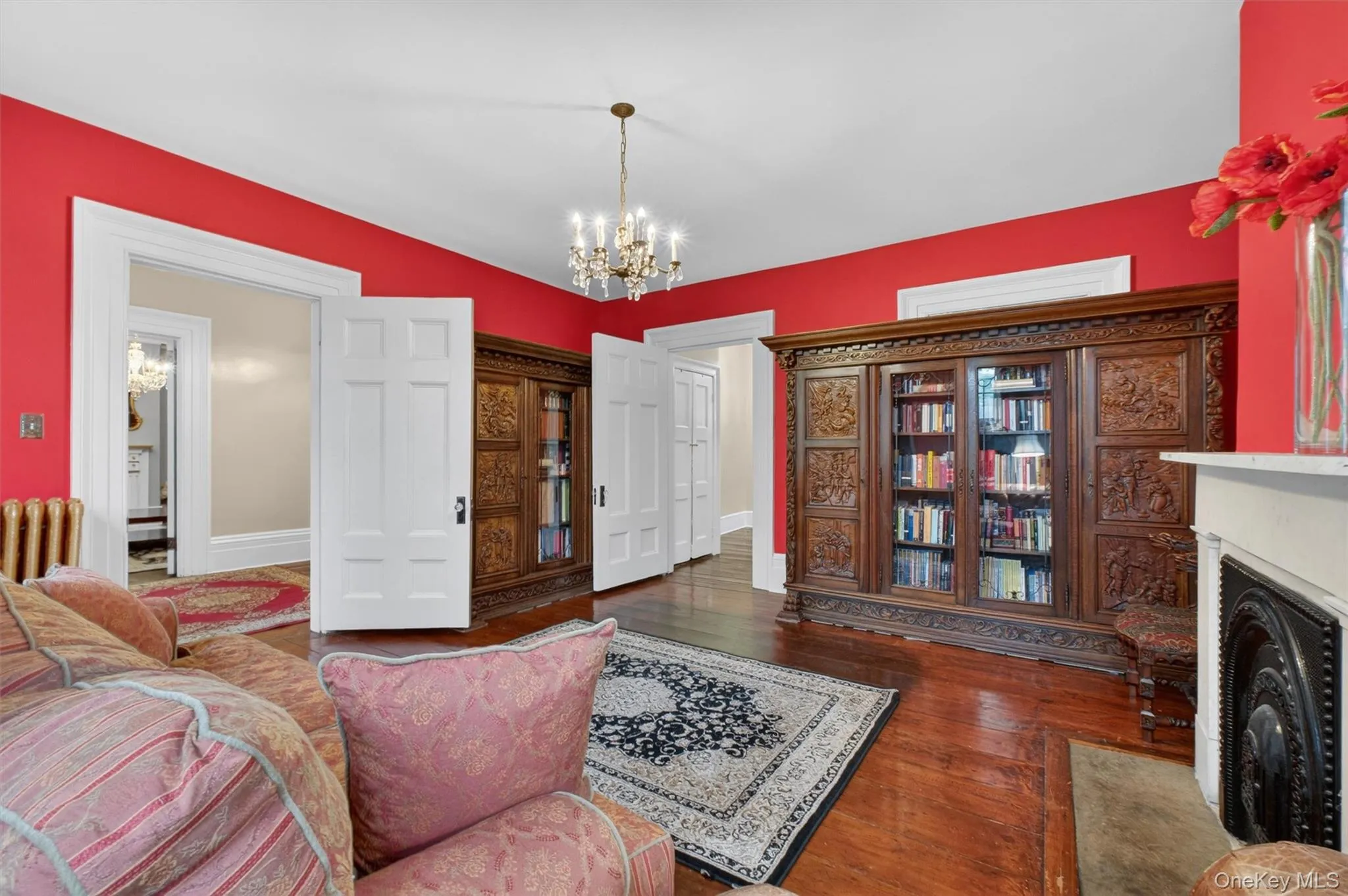 Hardwood flooring throughout, with a fireplace, large windows and doorway leading to other living areas Hardwood flooring throughout, with a fireplace, large windows and doorway leading to other living areas