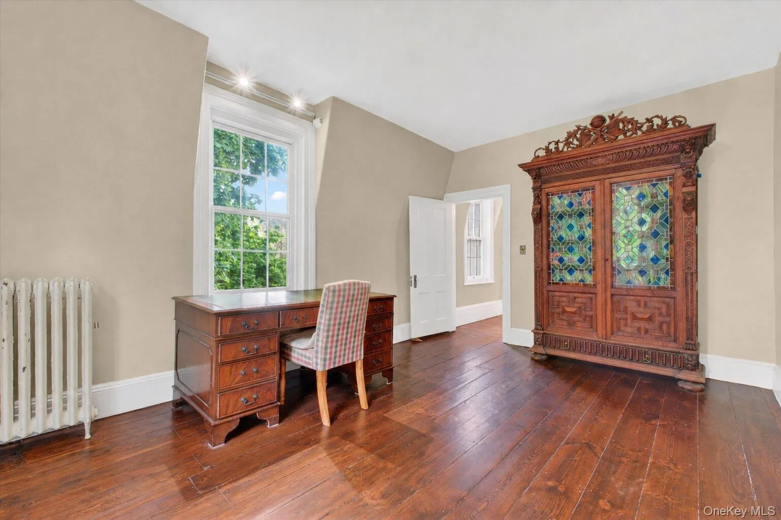Room featuring wide-plank wood flooring, light-toned walls, white trim,closet, and large windows. Room featuring wide-plank wood flooring, light-toned walls, white trim,closet, and large windows.
