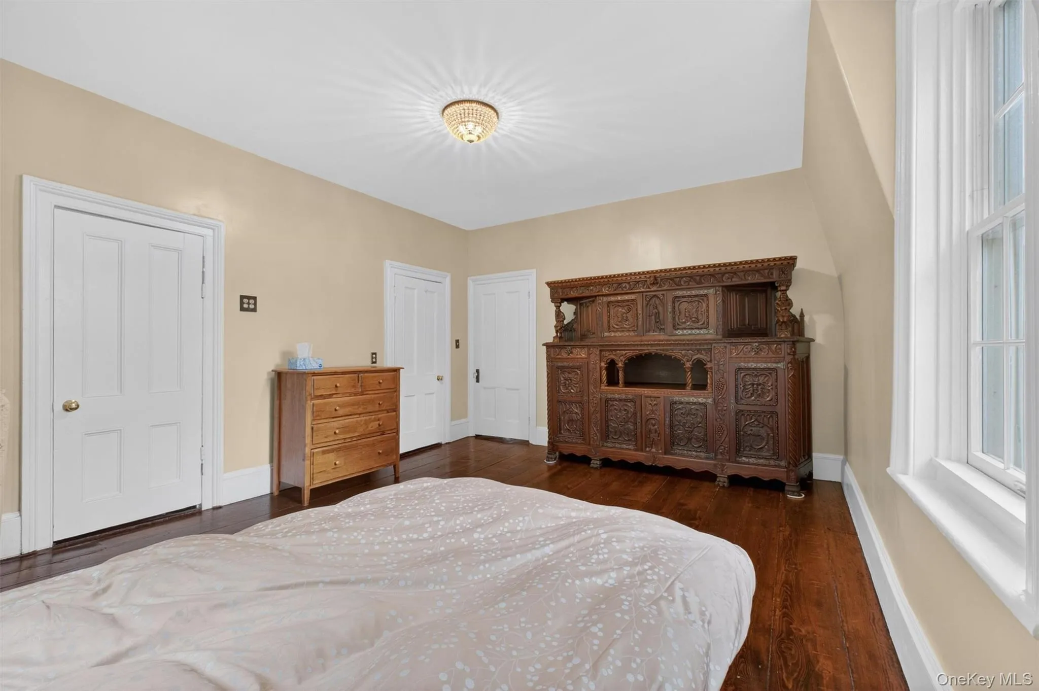 Room featuring wide-plank wood flooring, light-toned walls, white trim,closet, and large windows. Room featuring wide-plank wood flooring, light-toned walls, white trim,closet, and large windows.