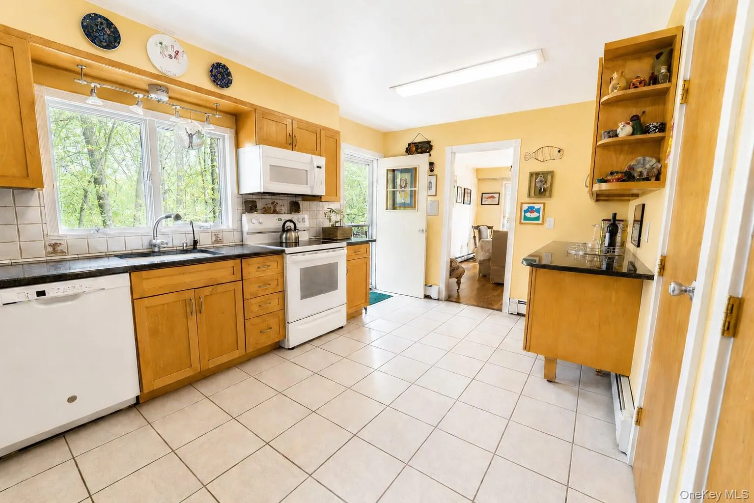 The kitchen boasts tile flooring, generous storage and workspace, and direct access to the side deck for convenient grilling and entertaining. The kitchen boasts tile flooring, generous storage and workspace, and direct access to the side deck for convenient grilling and entertaining.