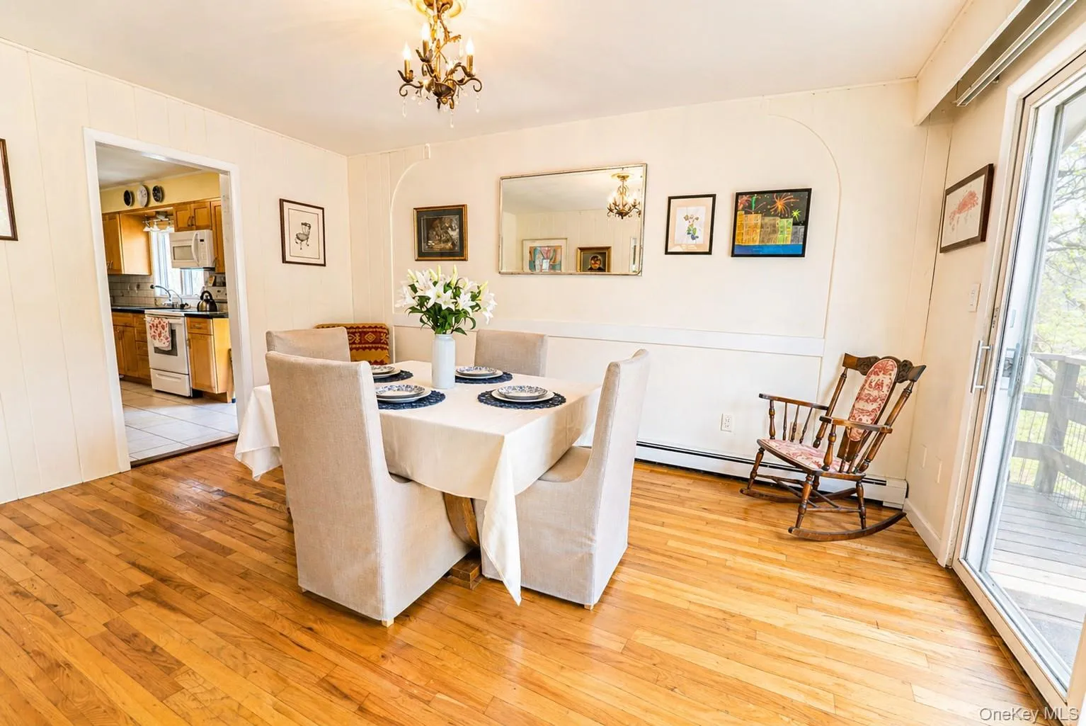 The elegant dining room features hardwood flooring, an antique chandelier, and seamless flow to the kitchen and living room. The elegant dining room features hardwood flooring, an antique chandelier, and seamless flow to the kitchen and living room.