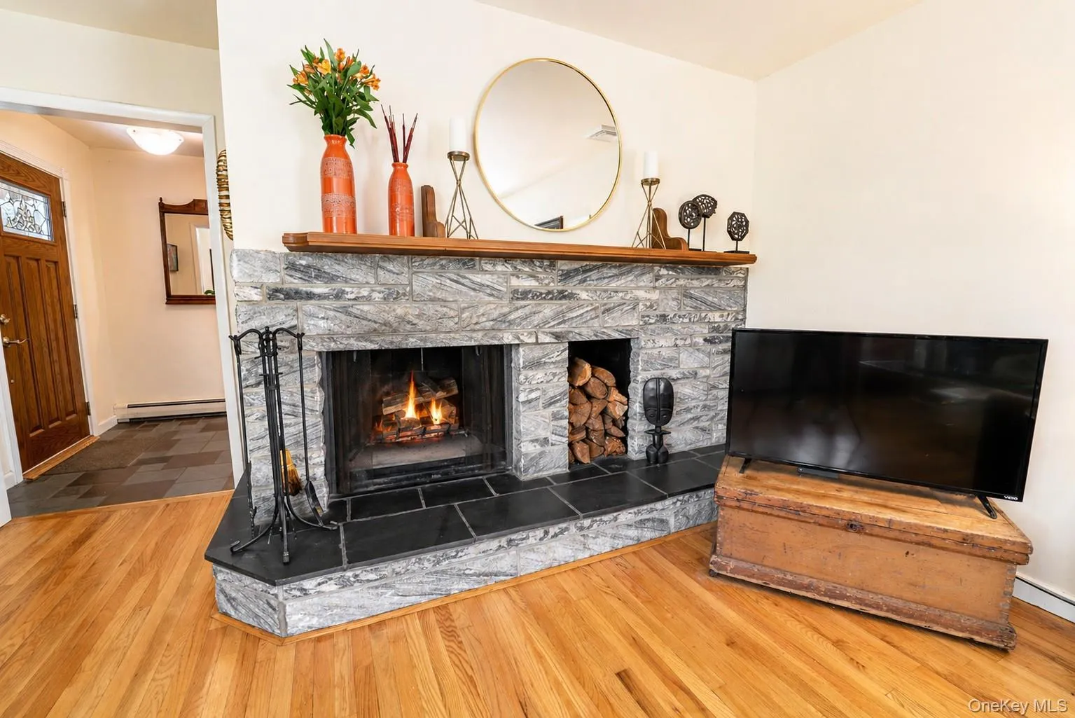 A beautiful wood-burning fireplace with striking stone accents and convenient wood storage serves as the focal point of the living room. A beautiful wood-burning fireplace with striking stone accents and convenient wood storage serves as the focal point of the living room.
