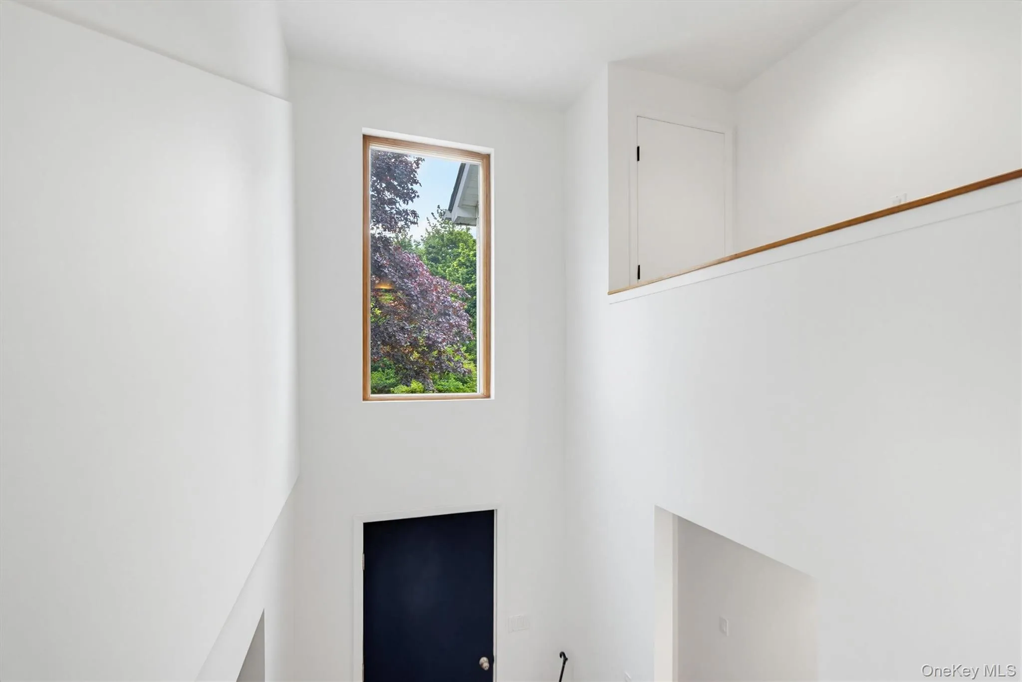A tall picture window across from the stairwell fills the entry with natural light and frames peaceful views of the surrounding greenery. A tall picture window across from the stairwell fills the entry with natural light and frames peaceful views of the surrounding greenery.
