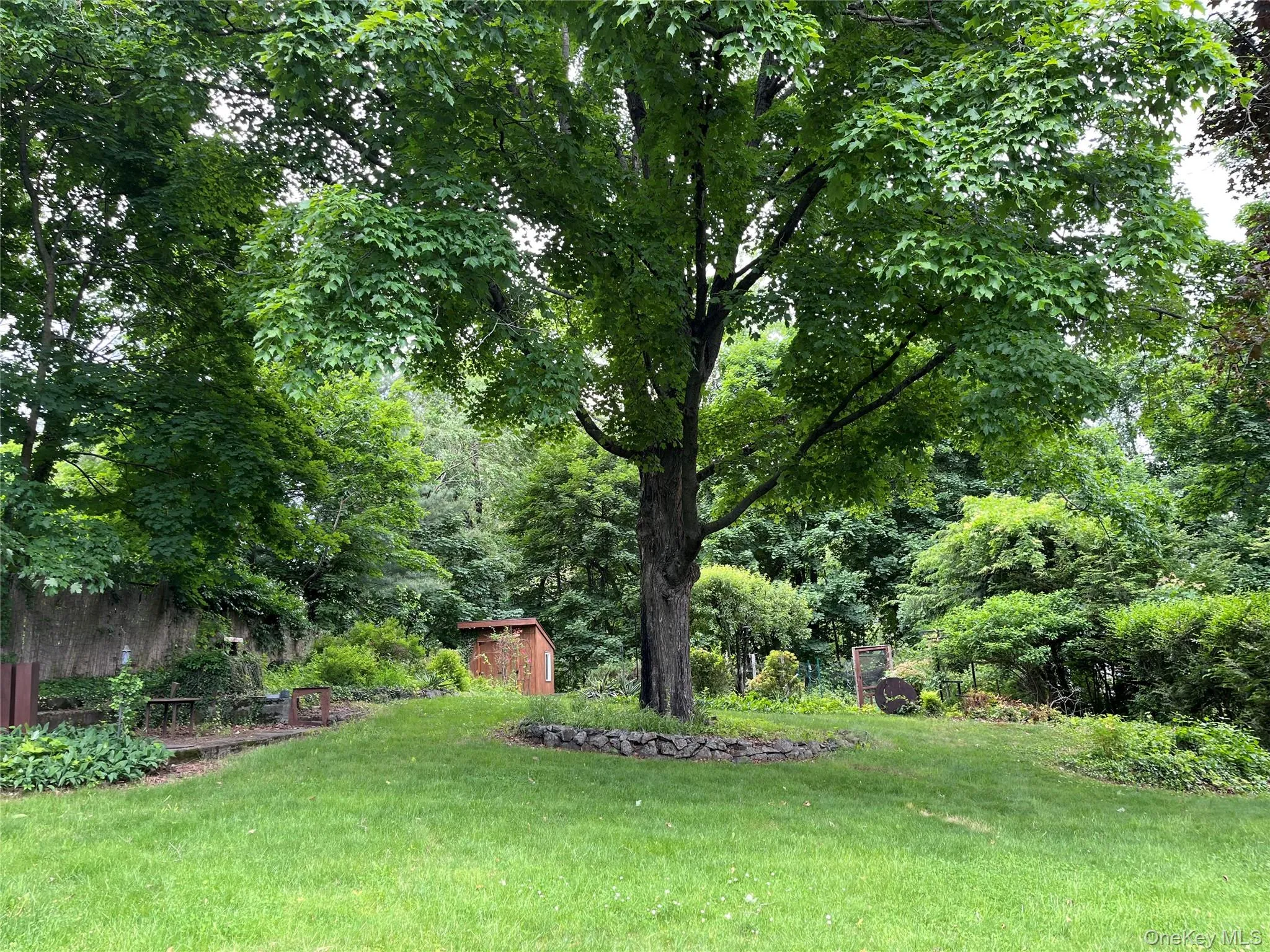 Backyard framed by mature trees and thoughtfully landscaped garden beds. Backyard framed by mature trees and thoughtfully landscaped garden beds.
