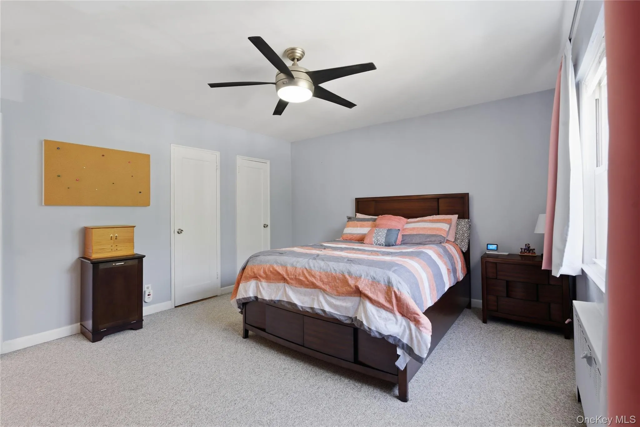 Bedroom featuring a ceiling fan with integrated lighting, three closets, light-toned carpet Bedroom featuring a ceiling fan with integrated lighting, three closets, light-toned carpet