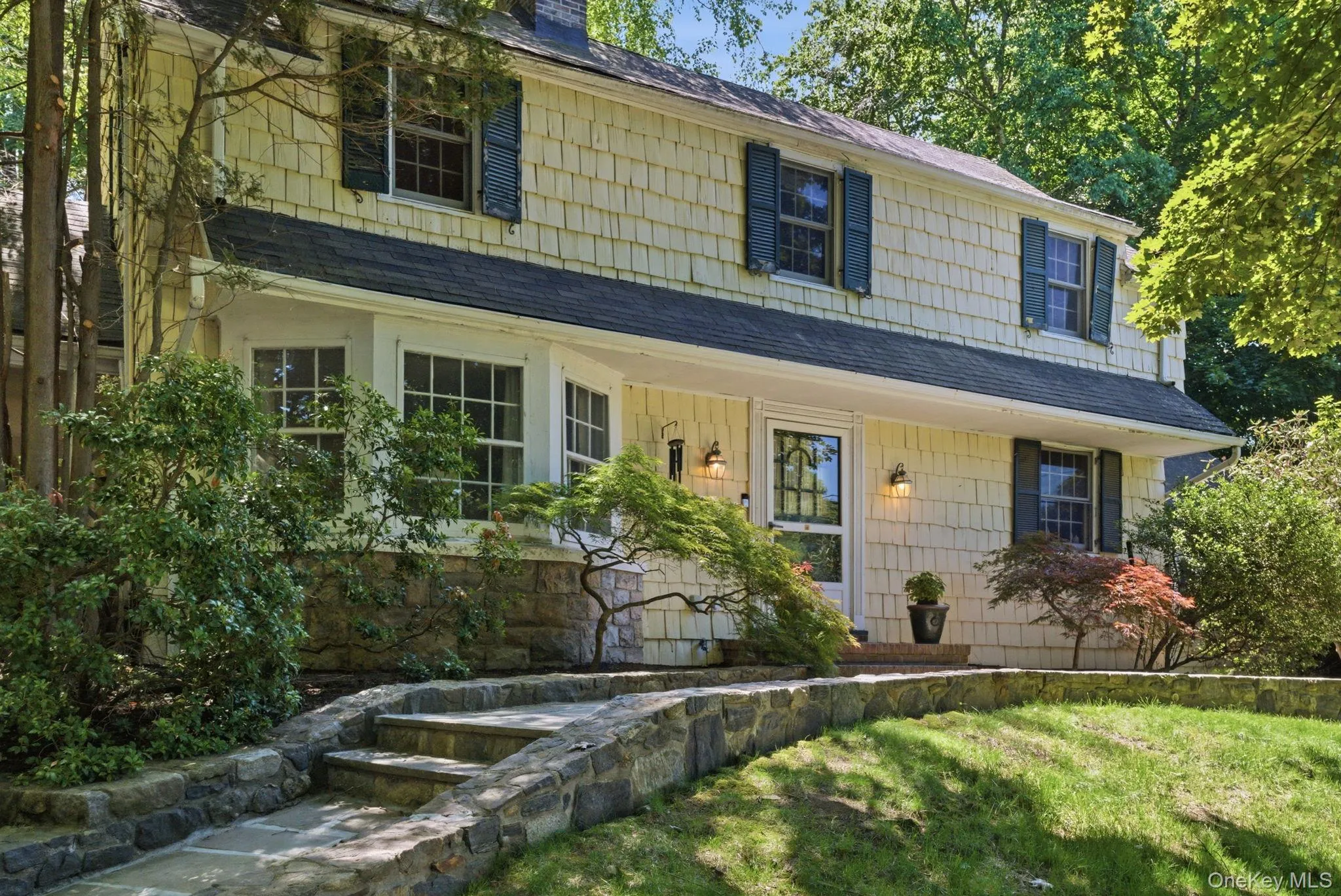The front entry is framed by stone walls, brick steps, and Japanese maples that speak to decades of careful planting. The front entry is framed by stone walls, brick steps, and Japanese maples that speak to decades of careful planting.