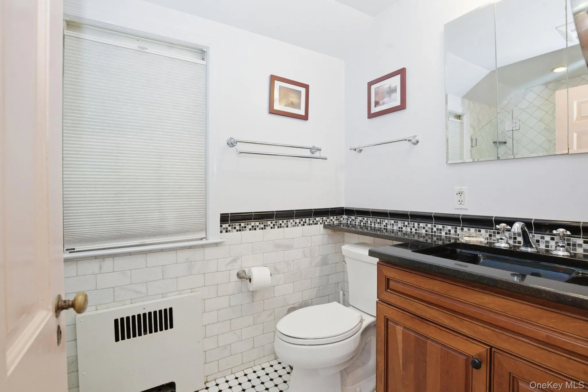 The primary ensuite features marble subway tile, a glass-enclosed shower, mosaic tile accents, and a granite vanity. The primary ensuite features marble subway tile, a glass-enclosed shower, mosaic tile accents, and a granite vanity.