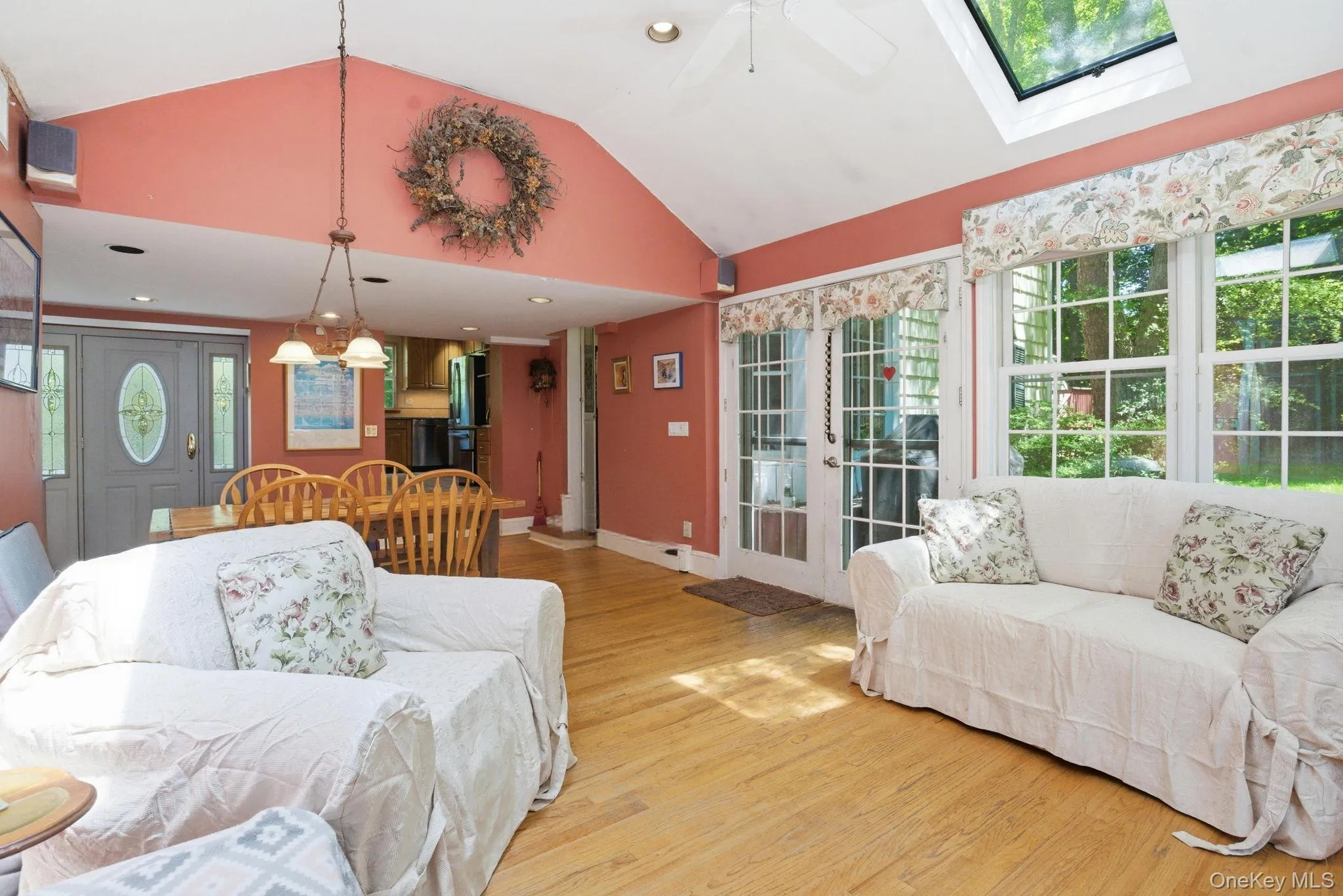 The family room features hardwood floors, vaulted ceiling with skylight, and French doors bringing in natural light from the yard. The family room features hardwood floors, vaulted ceiling with skylight, and French doors bringing in natural light from the yard.