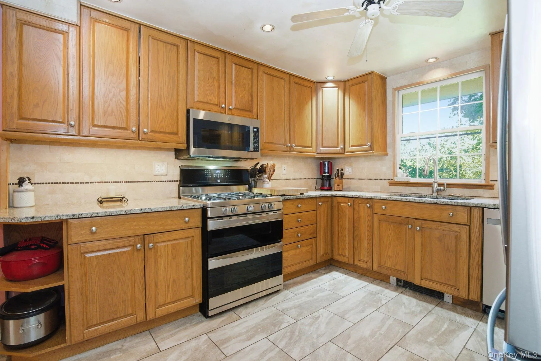 Wood cabinetry extending to the ceiling and a tile backsplash with mosaic accent strip give this kitchen its warm, functional character. Wood cabinetry extending to the ceiling and a tile backsplash with mosaic accent strip give this kitchen its warm, functional character.