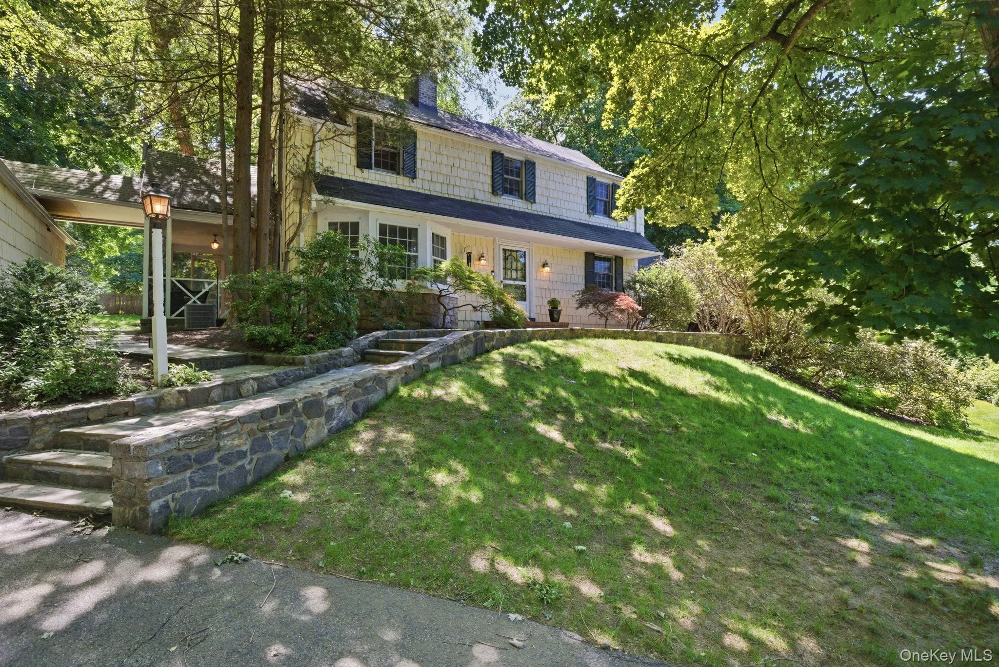 Flagstone steps, stone retaining walls, and established plantings create a distinctive approach to this 1934 Chappaqua Colonial. Flagstone steps, stone retaining walls, and established plantings create a distinctive approach to this 1934 Chappaqua Colonial.