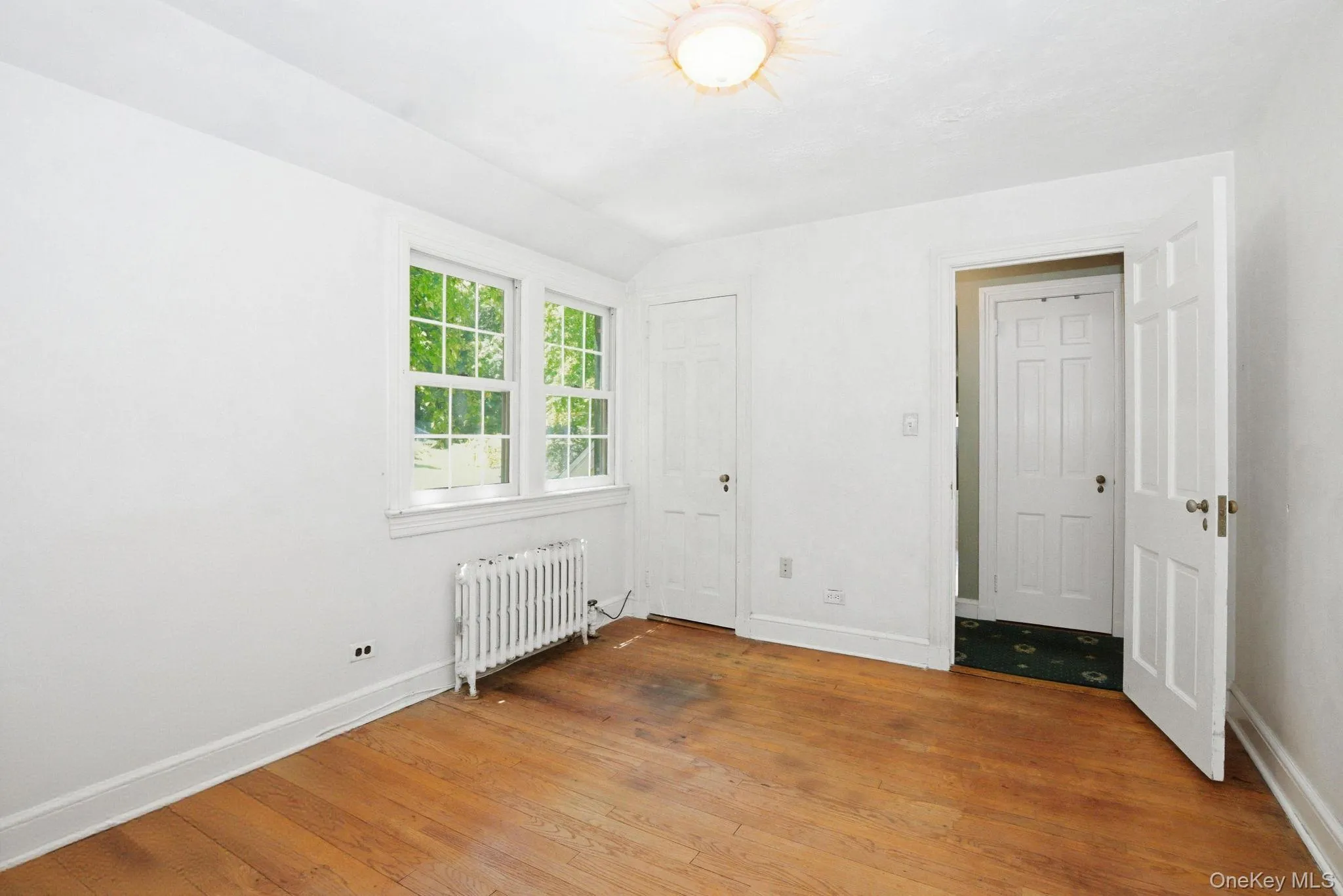 Original hardwood floors and tree-framed windows give this bedroom a solid foundation to make your own. Original hardwood floors and tree-framed windows give this bedroom a solid foundation to make your own.