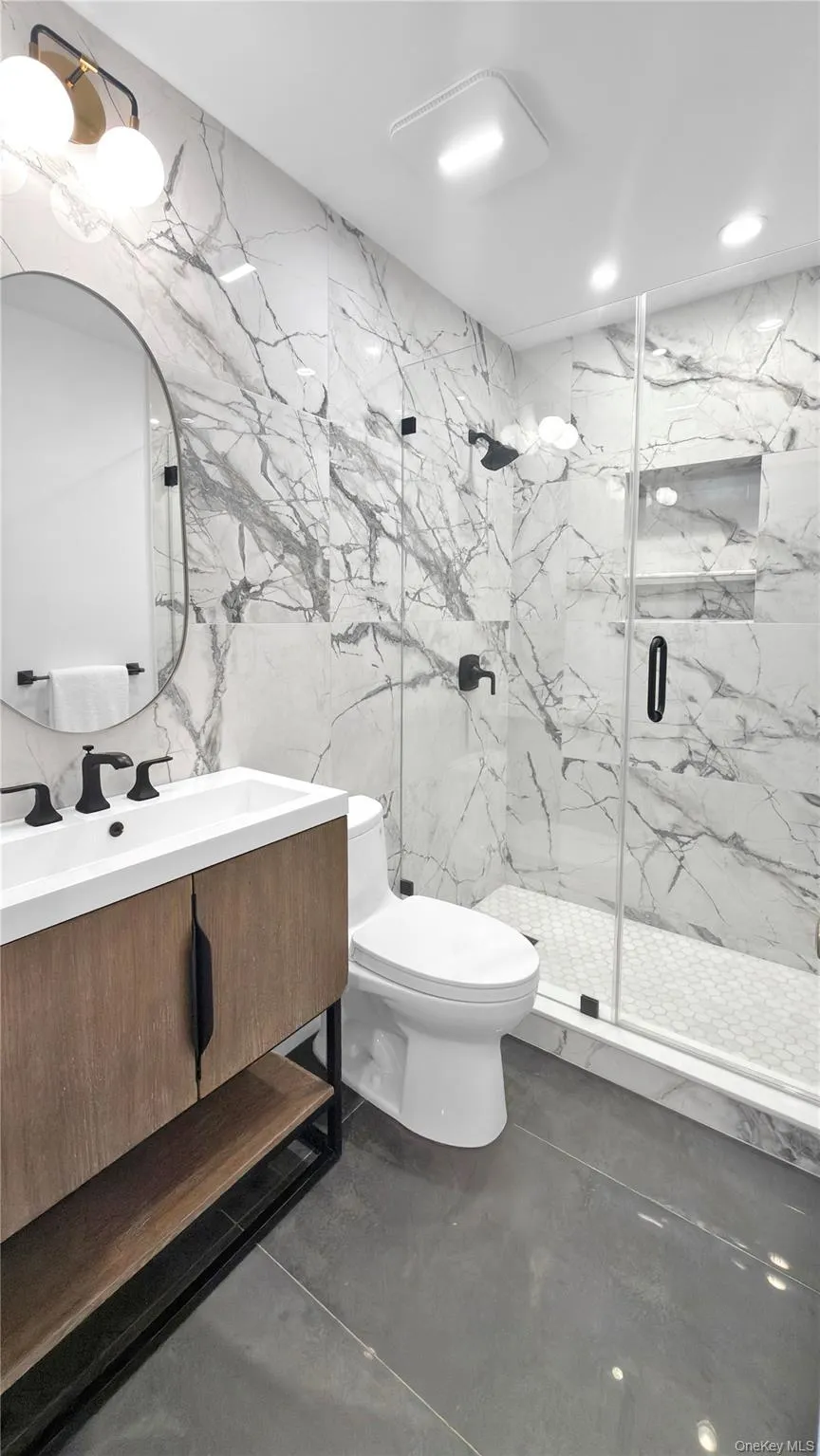 Modern bathroom featuring large format gray floor tiles Modern bathroom featuring large format gray floor tiles
