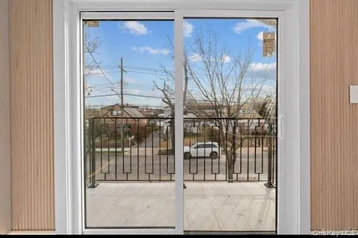 Sliding glass doors opening to a balcony with black metal railings Sliding glass doors opening to a balcony with black metal railings