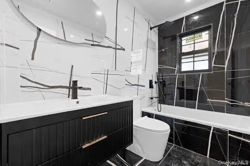 Modern bathroom featuring a black vanity with gold-tone hardware, a rectangular built-in sink, and a wall-mounted matte black faucet Modern bathroom featuring a black vanity with gold-tone hardware, a rectangular built-in sink, and a wall-mounted matte black faucet