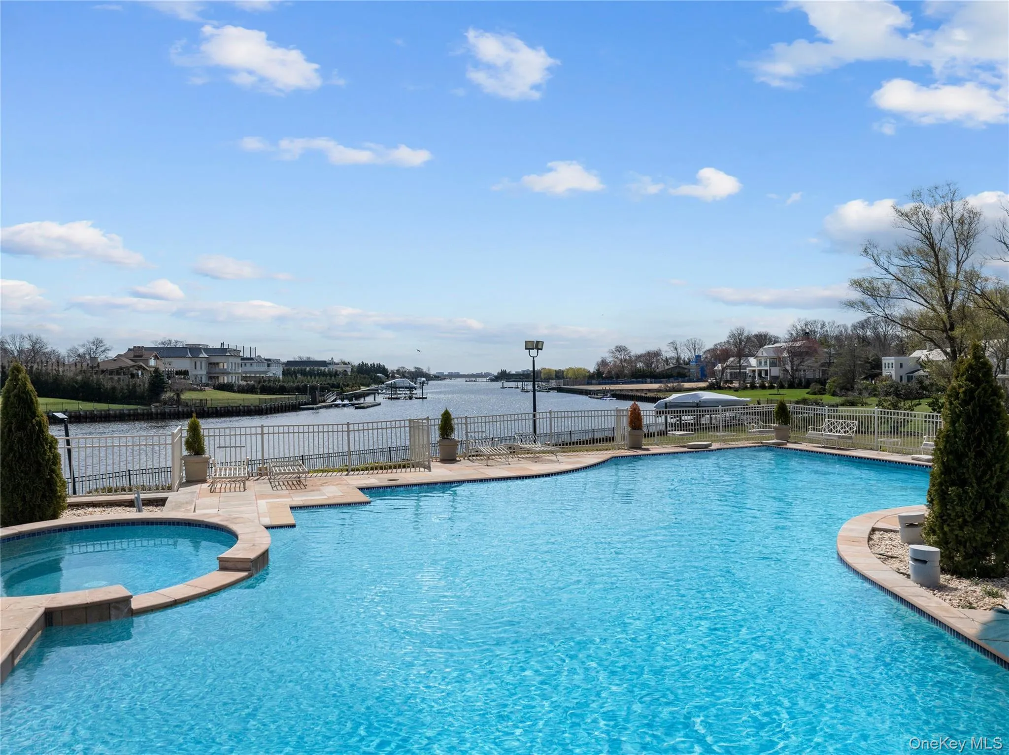 Expansive outdoor area featuring a freeform swimming pool and integrated spa, complemented by a water-front location Expansive outdoor area featuring a freeform swimming pool and integrated spa, complemented by a water-front location