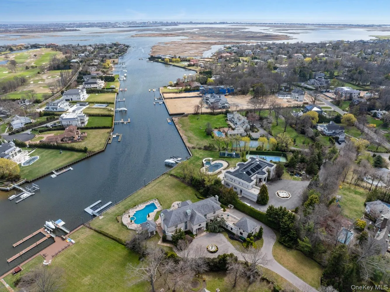 Waterfront property featuring a private dock, expansive lawn, and a large swimming pool Waterfront property featuring a private dock, expansive lawn, and a large swimming pool