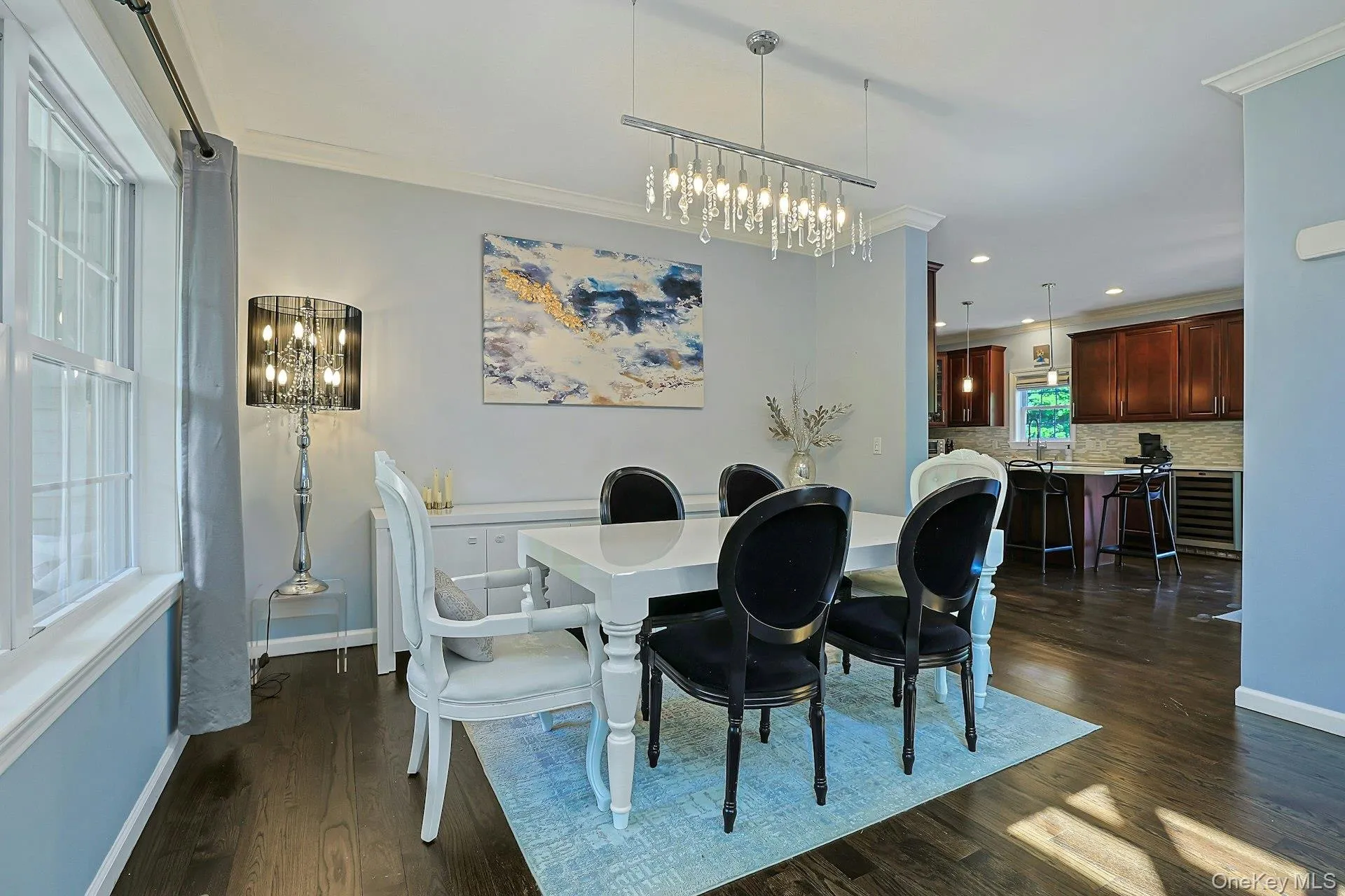 Dining space featuring hardwood flooring, crown molding, gorgeous lighting and an impressive welcome to this fabulous home to the left of the entry opposite the living room. Dining space featuring hardwood flooring, crown molding, gorgeous lighting and an impressive welcome to this fabulous home to the left of the entry opposite the living room.