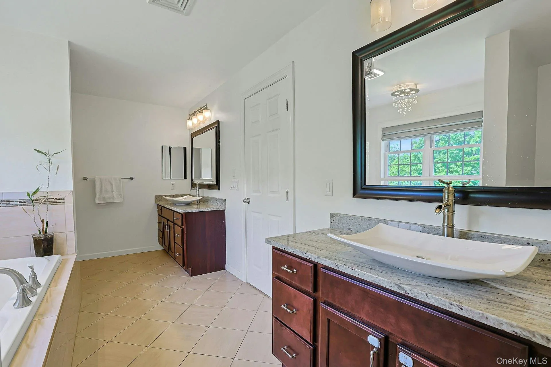 Primary bathroom featuring separate double sinks and vanities, so important for ease and convenience. Primary bathroom featuring separate double sinks and vanities, so important for ease and convenience.