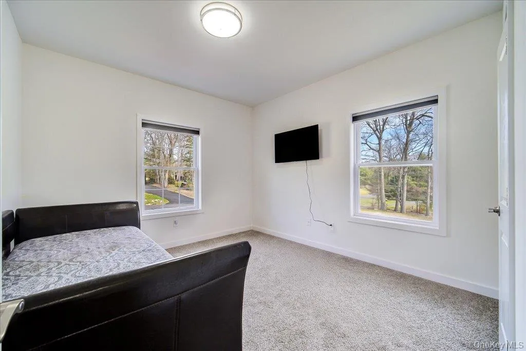 Room with light gray carpet flooring, white walls, and two double-hung windows with white trim Room with light gray carpet flooring, white walls, and two double-hung windows with white trim