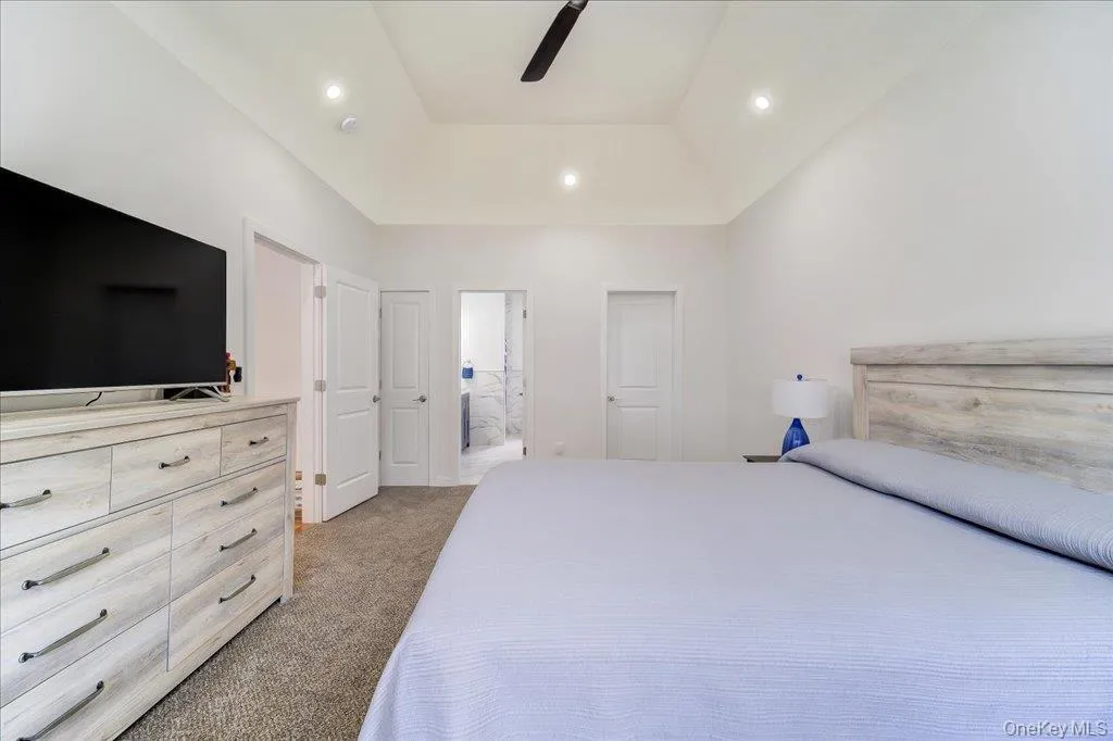 Carpeted room featuring a vaulted ceiling with recessed lighting and a ceiling fan Carpeted room featuring a vaulted ceiling with recessed lighting and a ceiling fan
