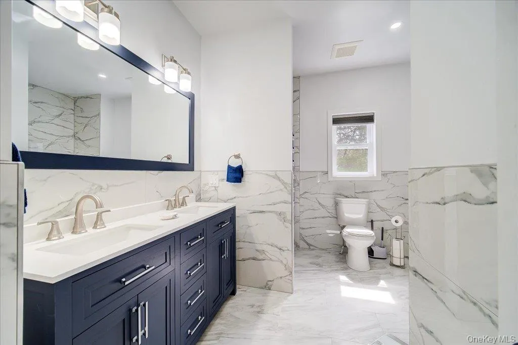 Dual vanity with undermount sinks, brushed nickel faucets, and a dark blue base cabinet Dual vanity with undermount sinks, brushed nickel faucets, and a dark blue base cabinet